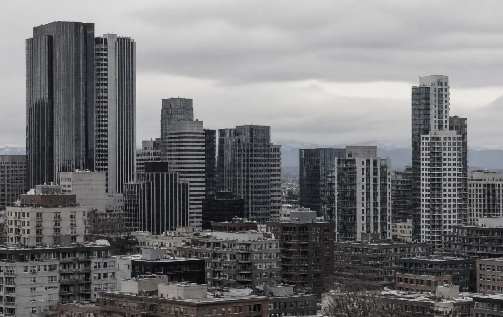 Denver downtown commercial office and multifamily towers with the Front Range behind